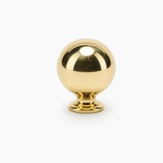 a golden door knob on a white background, with the top part of it turned to look like an orb