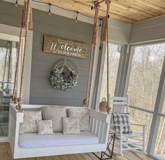 a porch swing with pillows on it