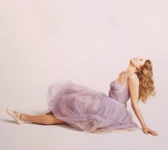 a woman laying on the ground in a purple dress