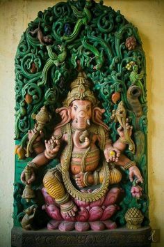 an intricately carved ganesha statue in front of a wall