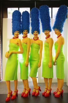 three women in green dresses with blue hair and red shoes standing next to each other