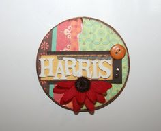 a close up of a button with the word harris on it and a red flower