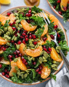 an orange and kale salad with pomegranates, nuts, and cranberries