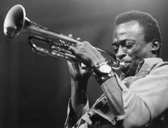 a black and white photo of a man playing a trumpet