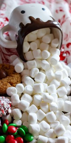 marshmallows, chocolate and candy are piled up in the shape of a dog