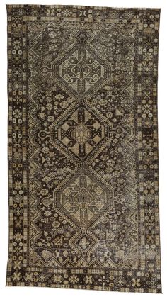 an antique rug with many different patterns and colors on the carpet, it is dark brown