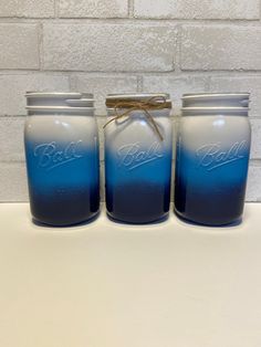 three jars with blue and white ombrellas are sitting on a table