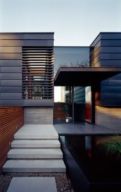 a modern house with steps leading up to the front door