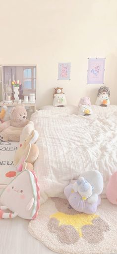 there are many stuffed animals sitting on the floor in this child's bed room