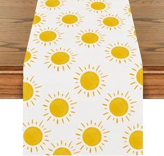 a yellow and white table runner with sun designs