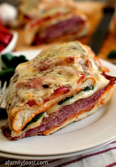 a close up of a sandwich on a plate with a fork and knife next to it