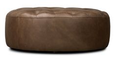 a brown leather ottoman sitting on top of a white floor