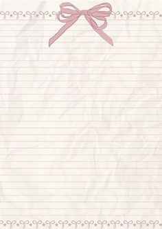 a notepad with a pink bow and ribbon on the top is lined in white paper