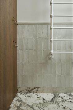 a bathroom with marble counter tops and white pipes in the shower wall, next to a wooden door