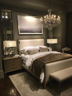 a bedroom with a large bed and chandelier