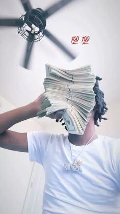 a man holding money in front of his face with a ceiling fan behind him that has the words $ 500 on it