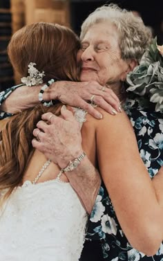 two women hugging each other and one is wearing a flowered dress with her arms around the other woman's neck