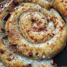 cinnamon buns with icing and nuts in a pan