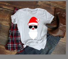 a t - shirt with sunglasses and santa hat on it, next to some jeans