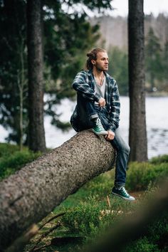 a man sitting on top of a fallen tree