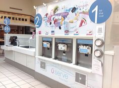 an ice cream machine is in the middle of a store's counter area with signs on it