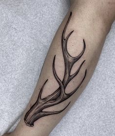 a black and white photo of a deer's antlers tattoo on the arm