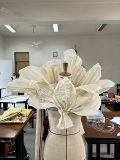 a mannequin with a hat on it's head in a room full of desks