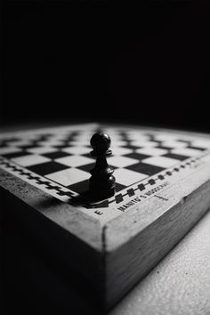 a black and white photo of a chess board with the king on it's side