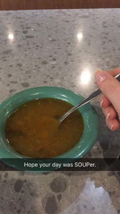 a person is holding a spoon over a bowl of soup on a table with the words hope your day was souper