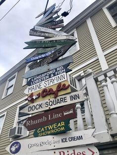 many signs are stacked on top of each other in front of a building with a sky background