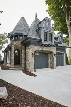 a large house with two garages on the front and one in the back, surrounded by trees