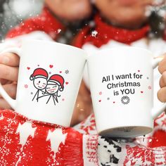 two people holding coffee mugs in their hands, with snow falling on the ground