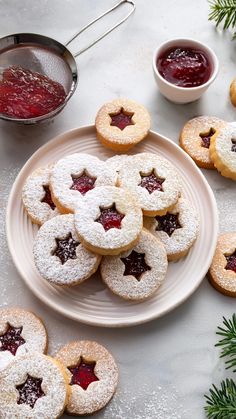 cookies with jam and powdered sugar on a plate