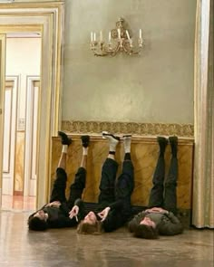 three people laying on the floor with their feet up in the air and one person upside down