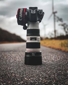 a canon camera sitting on top of a large stack of stacked up cameras'legs