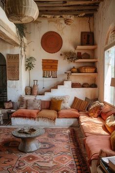 a living room filled with lots of furniture and pillows on top of a carpet covered floor