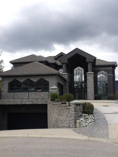 a large house with a car parked in front of it and an overcast sky