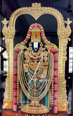 an elaborately decorated statue is displayed in a glass case