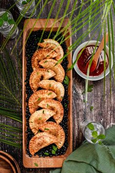 an overhead view of some food on a wooden platter next to other dishes and utensils