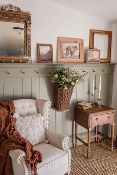 a living room with pictures on the wall and a chair in front of a fireplace