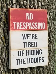 a no trespassing sign posted on a tree