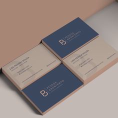 three business cards stacked on top of each other in front of a beige and blue background