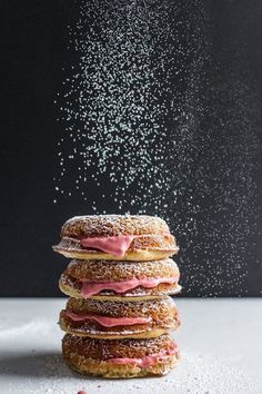 a stack of doughnuts with sprinkles falling from the top and bottom