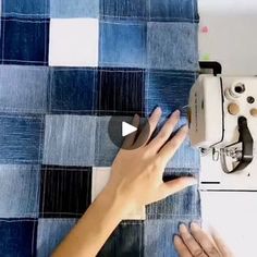 someone is using a sewing machine to sew something on a blue and white checkered table cloth