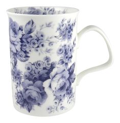 a blue and white coffee cup with purple flowers on the outside, in front of a white background