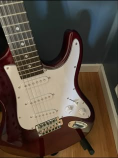 an electric guitar sitting on top of a wooden floor