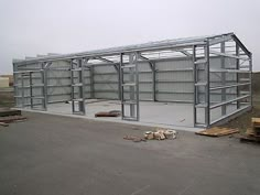 an empty warehouse with metal structures and wood pallets on the ground next to it