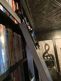 a bookshelf filled with lots of books next to a metal book shelf full of books