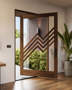 an open door with a decorative design on the glass and wood frame, in front of a brick wall