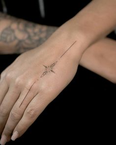 a woman's hand with a small tattoo on it